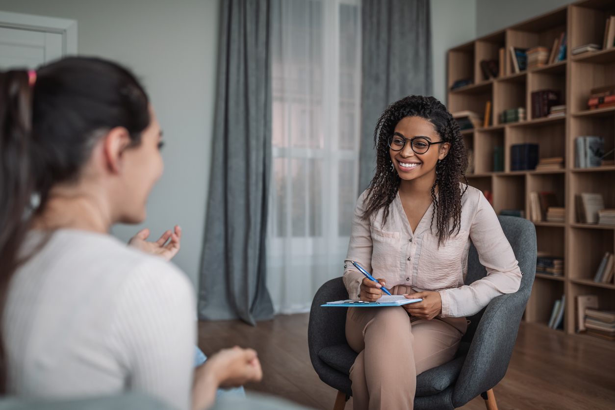 Smiling young black female counselor working with a client.